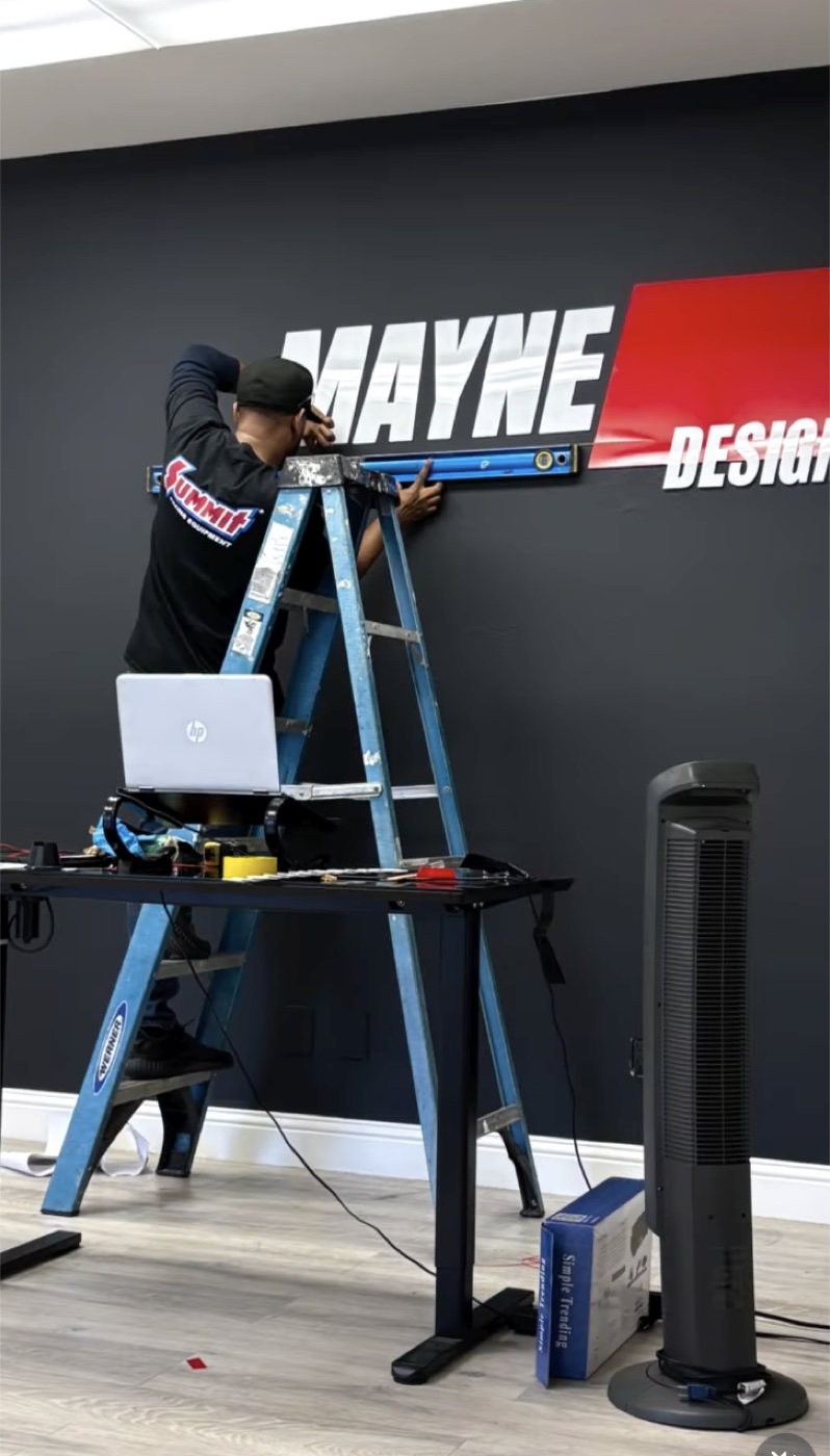 Markus Mayne installing the new shop sign